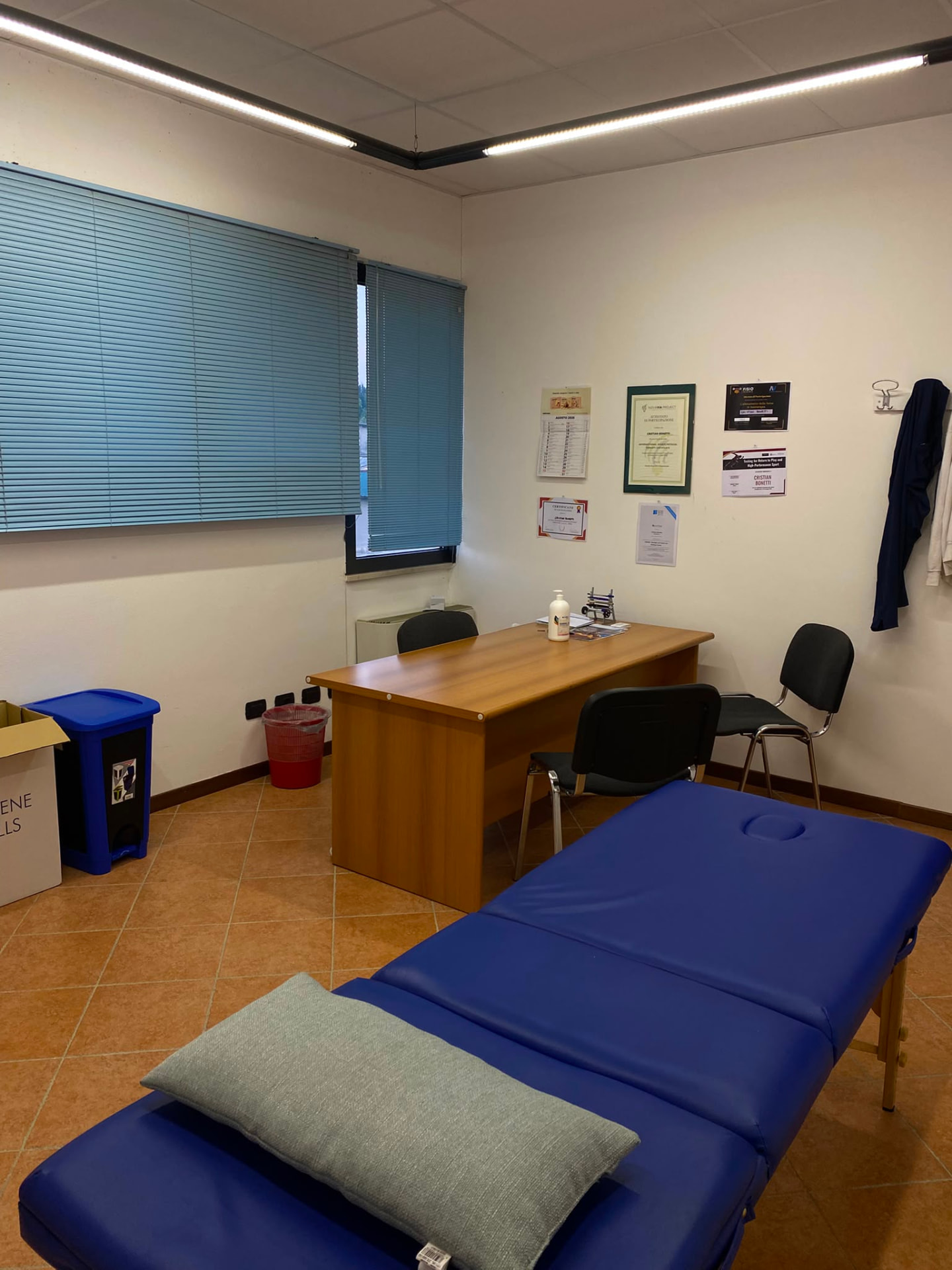 Sala trattamenti dello studio con lettino e attestati alle pareti