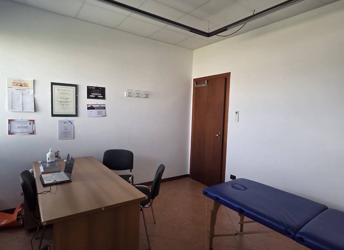 Studio di trattamento con lettino, scrivania e attestati